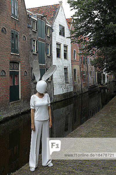 Frau mit Hasenmaske steht auf Fußweg