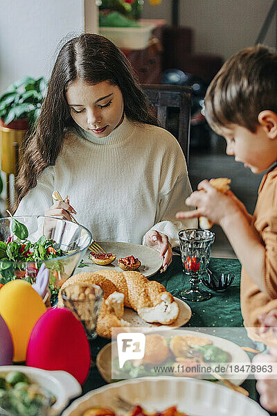 Boy with sister having Easter dinner at home
