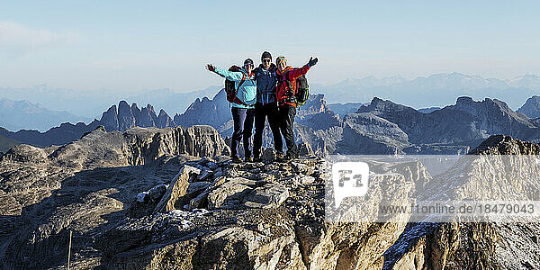 Happy friends standing together at Piz Boe  Dolomites  Italy