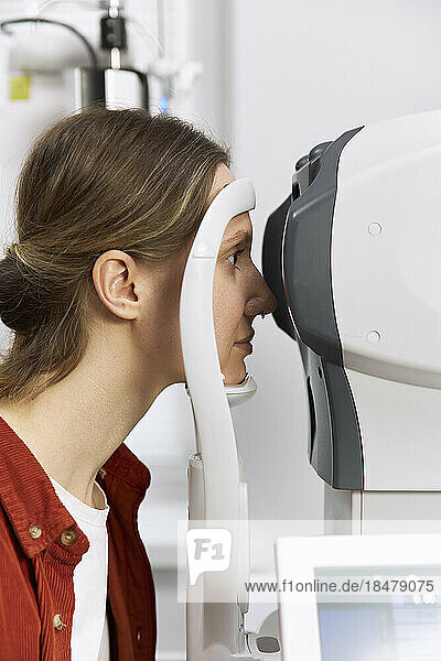 Patient führt Augenuntersuchung mit modernen Geräten in einer medizinischen Klinik durch