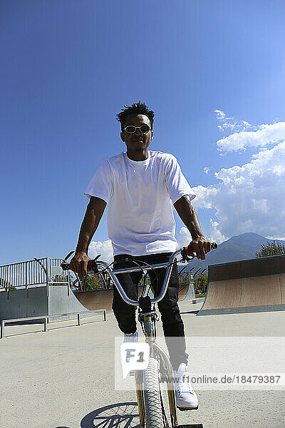 Mann fährt BMX-Fahrrad an sonnigem Tag im Skatepark