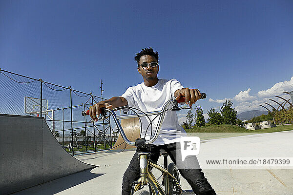 Young man sitting on BMX bike