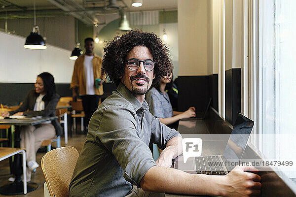 Businessman with curly hair sitting at workplace