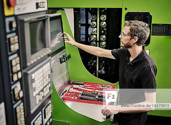 Technician operating machine in modern factory