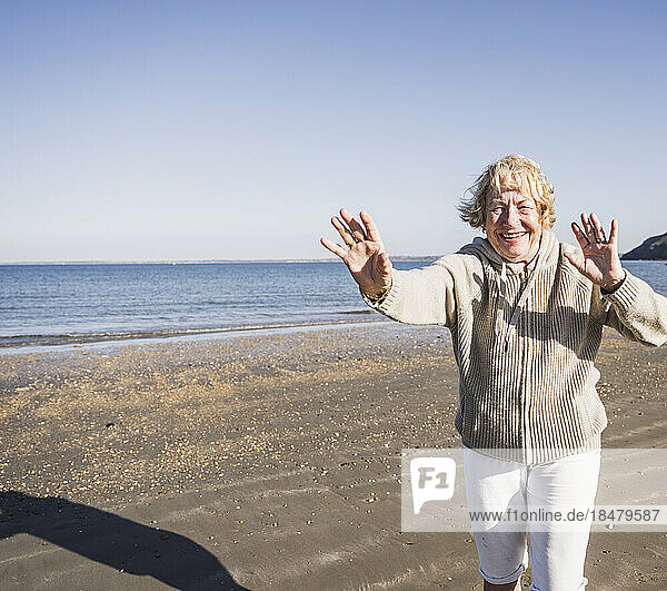 Fröhliche ältere Frau am Strand an einem sonnigen Tag