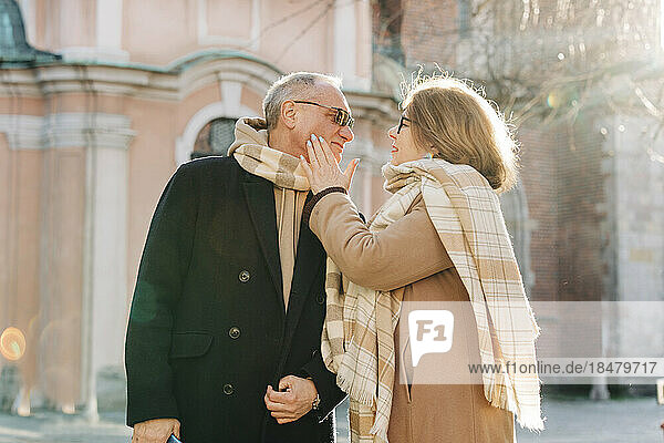 Romantic senior woman touching cheek of man