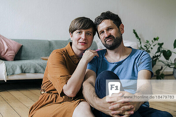 Smiling mature couple sitting in living room at home