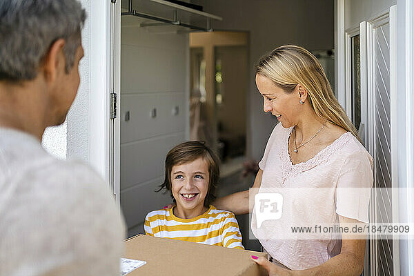 Mother and son receiving parcel at the front door