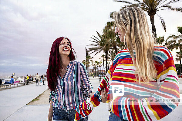 Fröhliche Freunde  die Spaß beim Spazierengehen an der Promenade haben