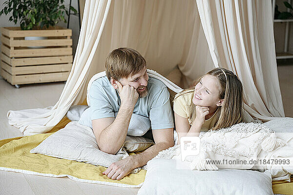 Happy father and daughter in tent at home
