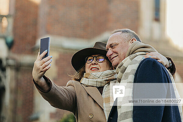 Happy elderly couple taking selfie through smart phone