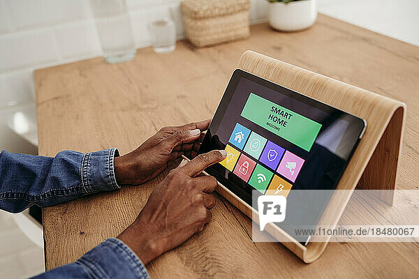 Hands of woman using home automation app on tablet PC