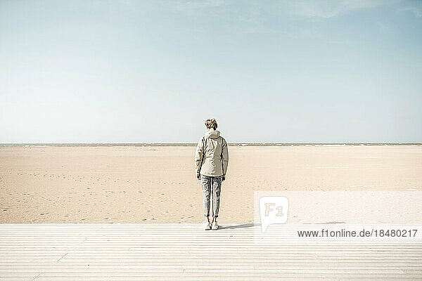 Woman standing on boardwalk at beach