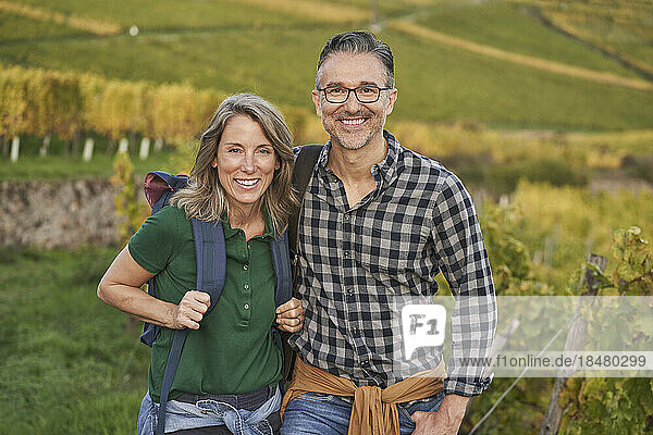 Happy mature woman and man standing together on hill