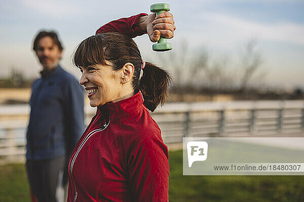 Happy mature woman with man exercising in park