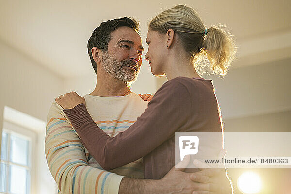 Romantic mature man embracing woman at home