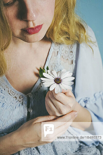 Blond woman holding white flower