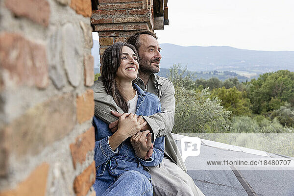 Smiling man and woman sitting on rooftop