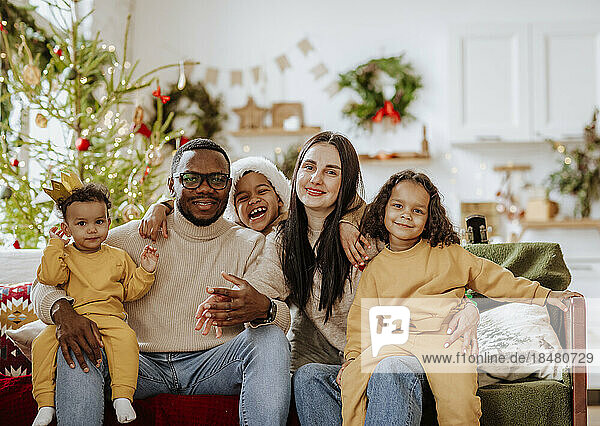 Glückliche Familie  die zu Weihnachten zusammen auf dem Sofa sitzt