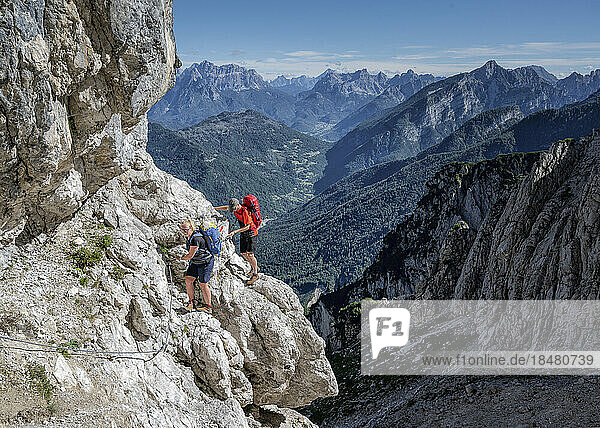 Couple rock climbing on sunny day at Dolomiti Bellunesi National Park Forcella Comedon  Dolomites  Italy