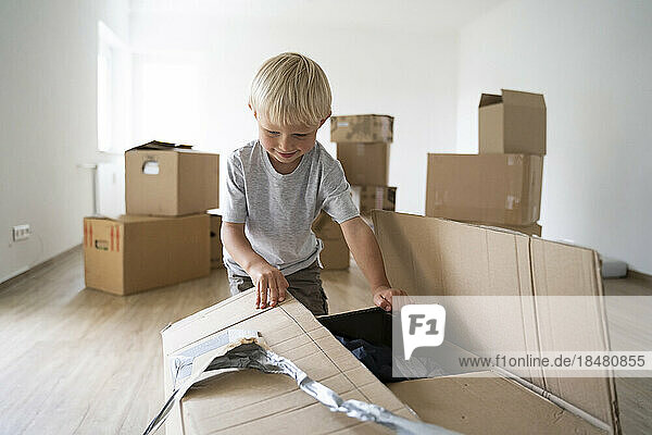 Boy opening cardboard at home