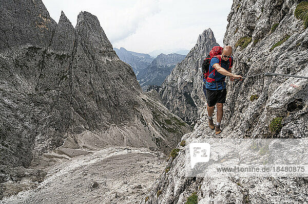 Man doing rock climbing at Passo del Ball  dolomites  Italy