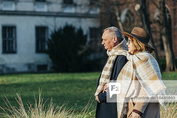 Senior couple wearing warm clothing walking in park