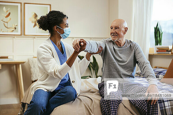 Physiotherapeut untersucht älteren Mann zu Hause