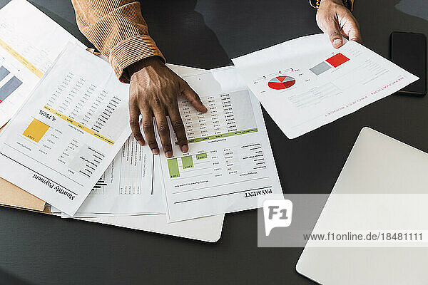 Hands of businessman with documents on desk