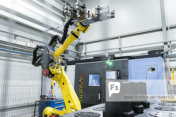 Robotic arm with machinery in factory