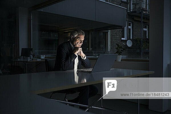 Geschäftsmann beobachtet Laptop am Schreibtisch im Büro