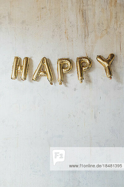 Happy text made with inflated balloons hanging on wall