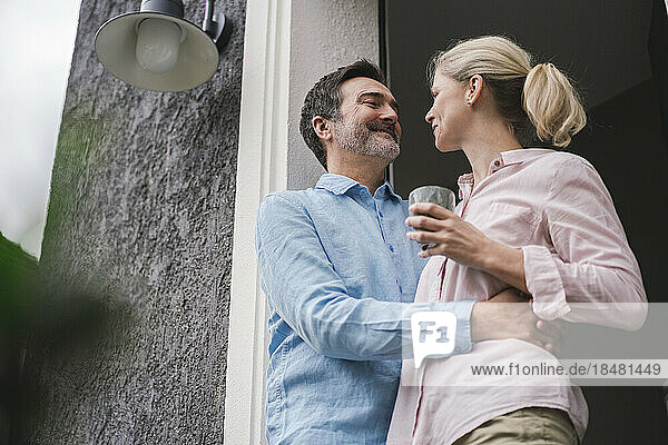 Lächelndes älteres Paar  das vor der Tür miteinander redet