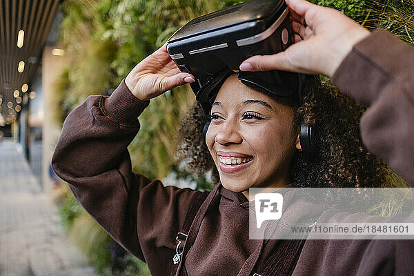 Happy young woman with VR goggles