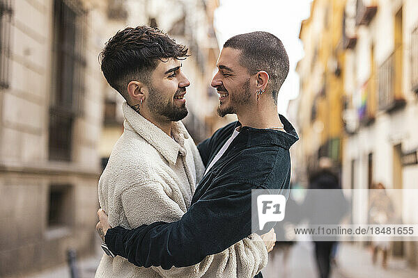 Glücklicher schwuler Mann umarmt seinen Freund auf der Straße