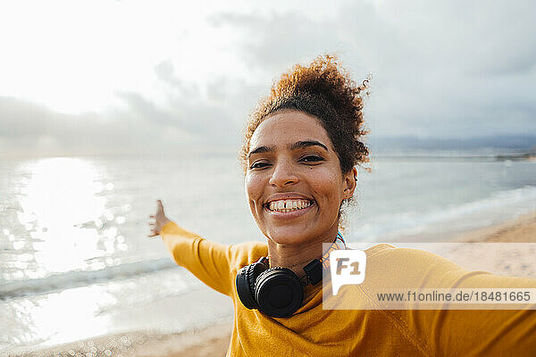 Happy young woman having fun at beach on sunny day