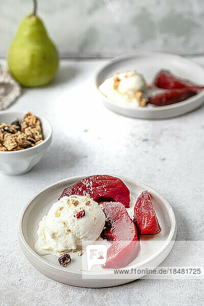 Pears in red wine with ice cream served on table