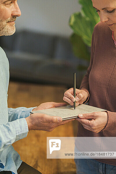 Mature salesman with customer signing agreement