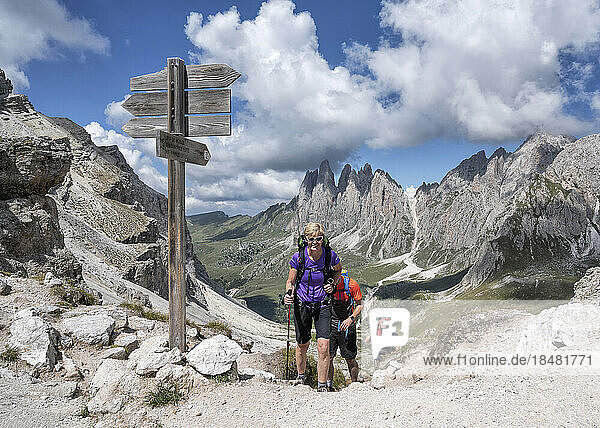 Women and man hiking under cloudy sky at Col da la Pieres  Dolomites  Italy