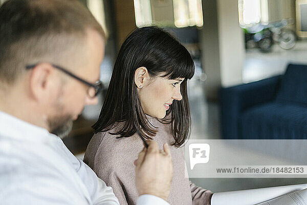 Businessman and woman discussing document in office