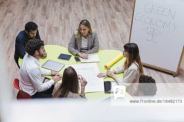 High angle view of business colleagues having a meeting with plan  wireless devices and solar panel on table