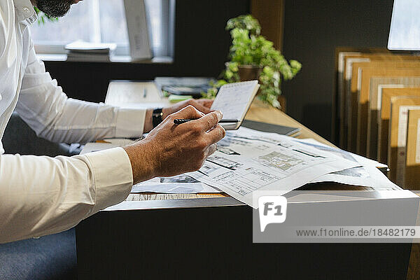 Businessman looking at plan in architect's office