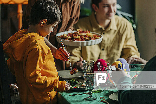 Boy with family having Easter dinner at home