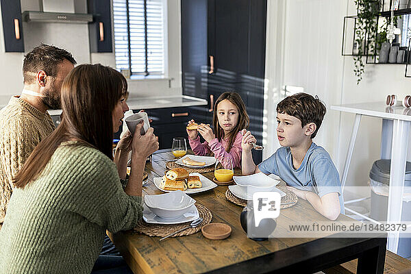 Family together having breakfast in kitchen at home