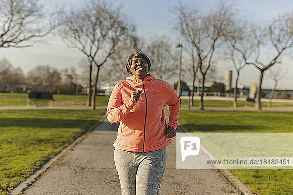Happy senior woman running at park