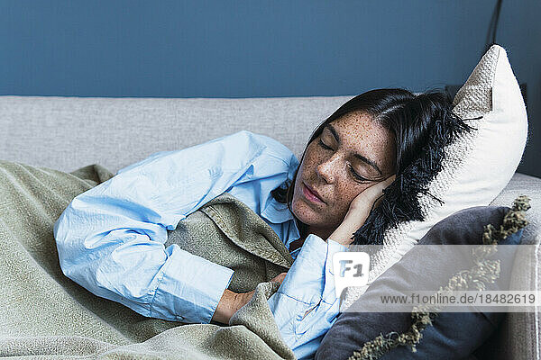 Young woman sleeping on sofa at home