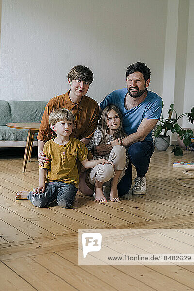 Smiling parents and children in living room at home