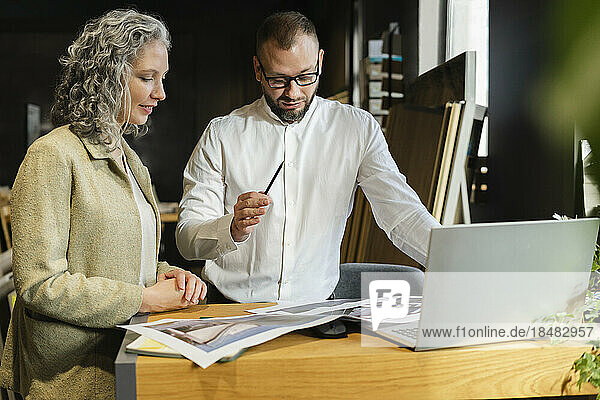 Two colleagues working together at table in architect's office