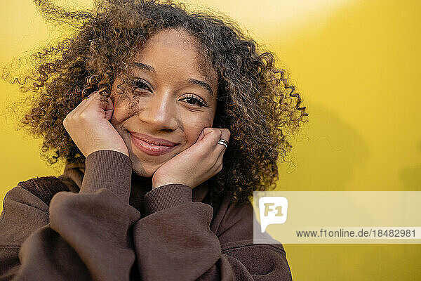 Smiling young woman with curly brown hair