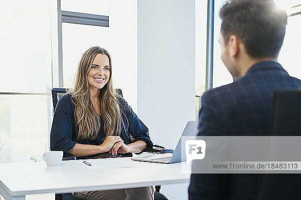 Smiling recruiter listening to candidate at office